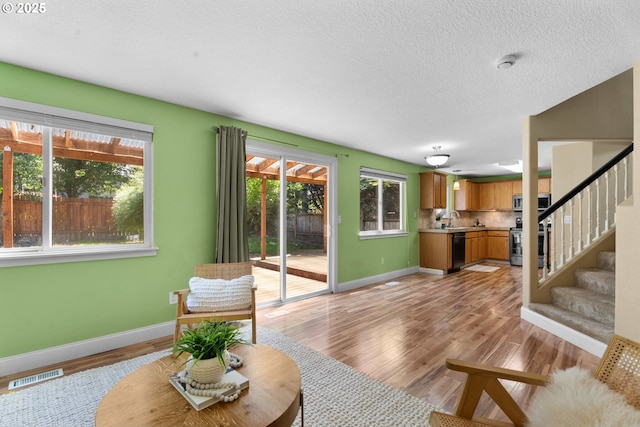 1601 NW 2nd Ave, Battle Ground, WA 98604 - living area featuring baseboards, light wood-style flooring, stairway, and a textured ceiling