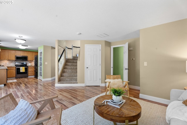 1601 NW 2nd Ave, Battle Ground, WA 98604 - living area with baseboards, light wood-style flooring, and stairs