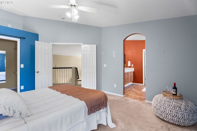 1601 NW 2nd Ave, Battle Ground, WA 98604 - carpeted bedroom featuring arched walkways, ensuite bath, baseboards, and ceiling fan