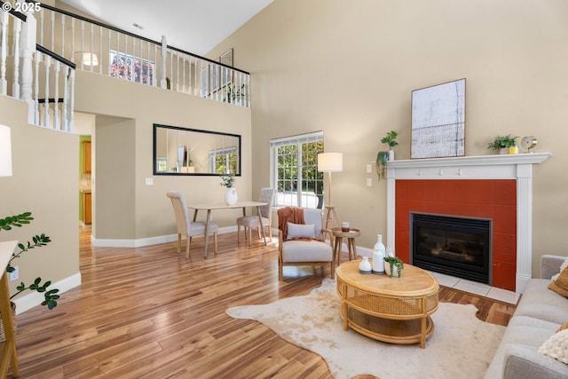 1601 NW 2nd Ave, Battle Ground, WA 98604 - living area featuring a tiled fireplace, wood finished floors, baseboards, and a high ceiling