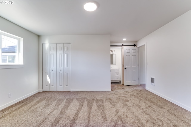85160 Larson Rd, Eugene, OR 97405 - unfurnished bedroom featuring baseboards, carpet floors, a barn door, connected bathroom, and recessed lighting