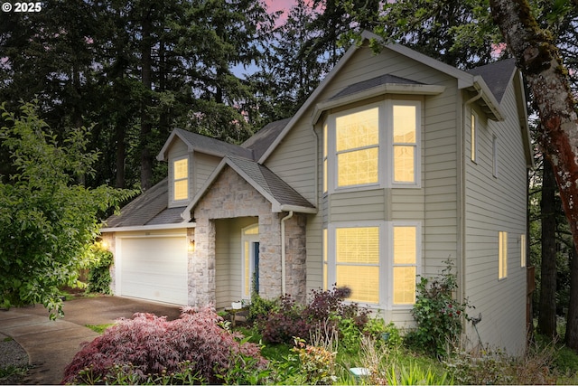 8503 SE 139th Ct, Portland, OR 97236 - traditional-style house featuring driveway, stone siding, a shingled roof, and a garage