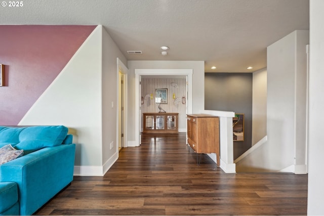 hallway with recessed lighting, wood finished floors, visible vents, and baseboards