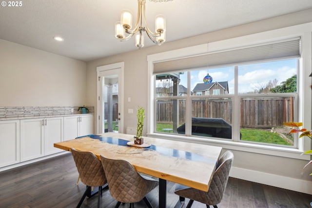 dining space featuring dark wood-style floors, recessed lighting, an inviting chandelier, and baseboards