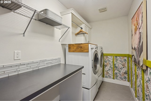 washroom featuring dark tile patterned floors, cabinet space, and independent washer and dryer