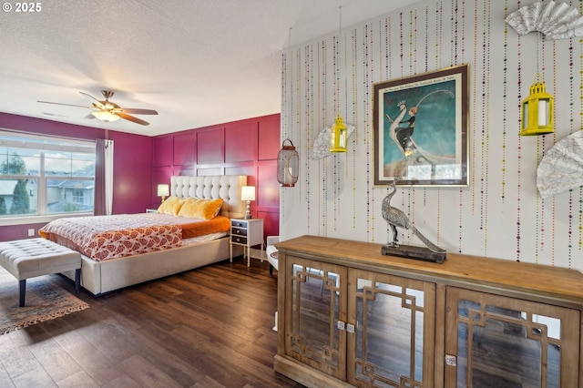 bedroom with a textured ceiling, ceiling fan, and dark wood-style flooring