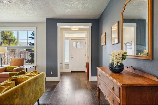 entryway with baseboards, a textured ceiling, and dark wood-style floors