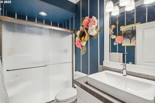 full bathroom featuring vanity, a shower stall, and toilet