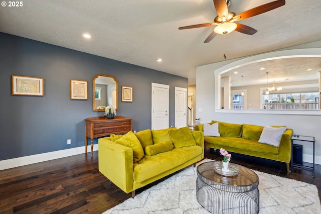 living room featuring baseboards, recessed lighting, ceiling fan with notable chandelier, wood finished floors, and arched walkways