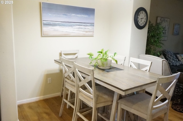dining room featuring wood finished floors and baseboards
