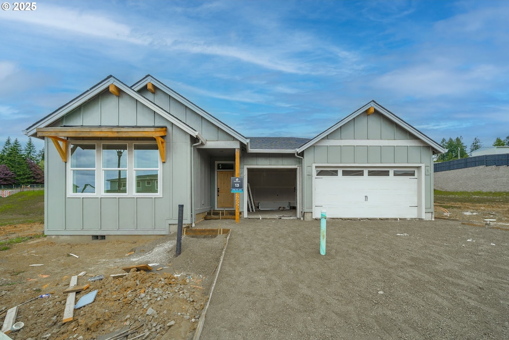 view of front of home with board and batten siding, an attached garage, and driveway