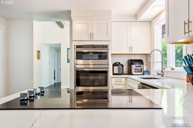 2022 Floral Hill Dr, Eugene, OR 97403 - kitchen with stainless steel appliances, a peninsula, a breakfast bar, white cabinets, and light countertops