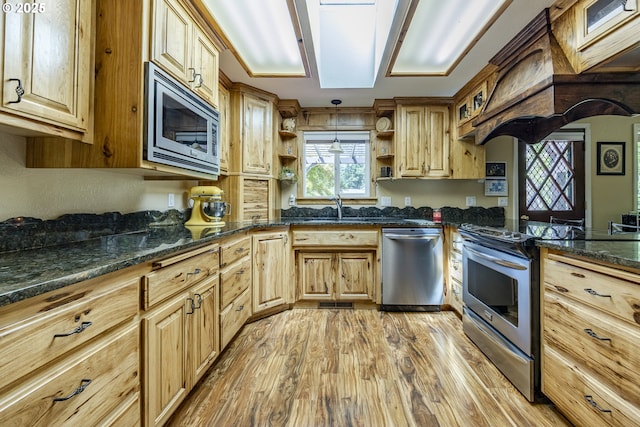 40211 Deerhorn Rd, Springfield, OR 97478 - kitchen with stainless steel appliances, open shelves, light wood-style floors, a sink, and custom range hood