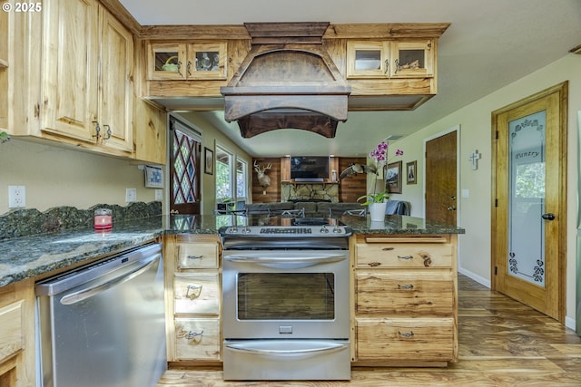 40211 Deerhorn Rd, Springfield, OR 97478 - kitchen with appliances with stainless steel finishes, light wood-style floors, dark stone countertops, and glass insert cabinets