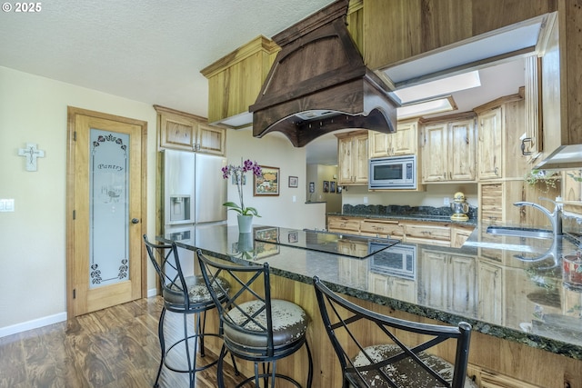 40211 Deerhorn Rd, Springfield, OR 97478 - kitchen with appliances with stainless steel finishes, custom range hood, a sink, dark stone countertops, and baseboards