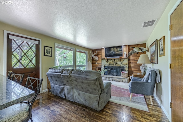 40211 Deerhorn Rd, Springfield, OR 97478 - living area with healthy amount of natural light, wood finished floors, a textured ceiling, a stone fireplace, and baseboards