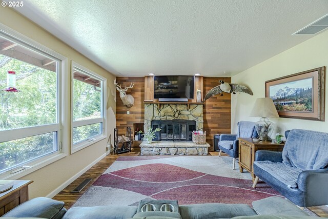 40211 Deerhorn Rd, Springfield, OR 97478 - living room with a textured ceiling, a fireplace, wooden walls, baseboards, and wood finished floors