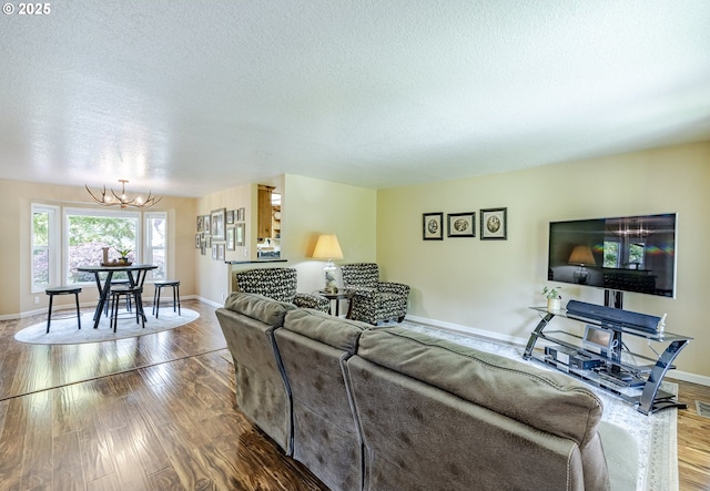 40211 Deerhorn Rd, Springfield, OR 97478 - living room featuring a chandelier, wood finished floors, a textured ceiling, and baseboards