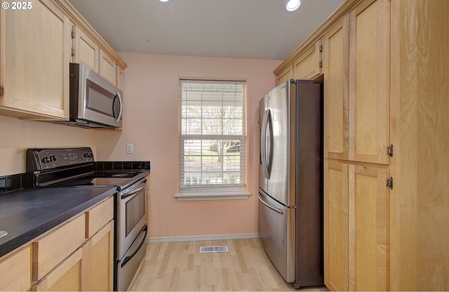 806 NW 15th Ave, Battle Ground, WA 98604 - kitchen with stainless steel appliances, light brown cabinetry, dark countertops, baseboards, and recessed lighting