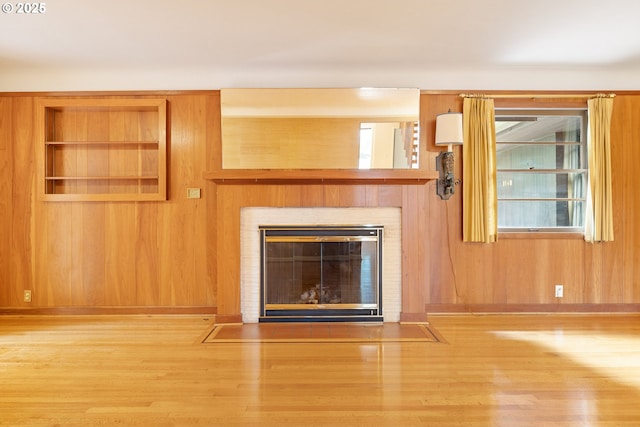 1940 SW 71st Ave, Portland, OR 97225 - detailed view of wood finished floors, a fireplace with flush hearth, baseboards, and wooden walls