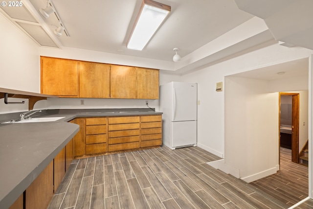 1940 SW 71st Ave, Portland, OR 97225 - kitchen with freestanding refrigerator, a sink, dark wood finished floors, and brown cabinets
