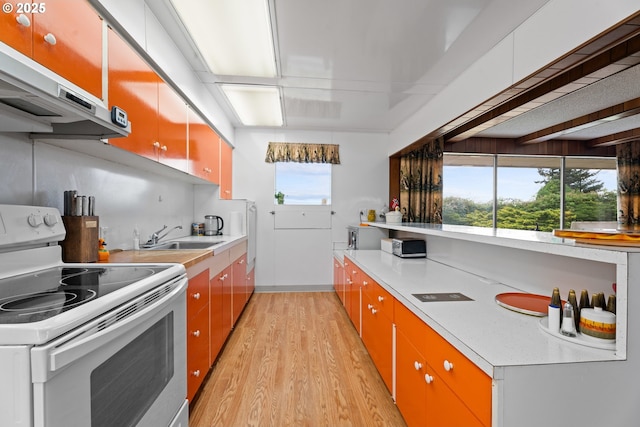 53767 E Honeyman Rd, Scappoose, OR 97056 - kitchen featuring white electric stove, light wood-style floors, exhaust hood, and light countertops