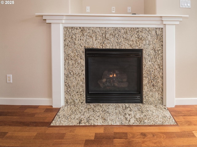 interior details featuring a premium fireplace, wood finished floors, and baseboards