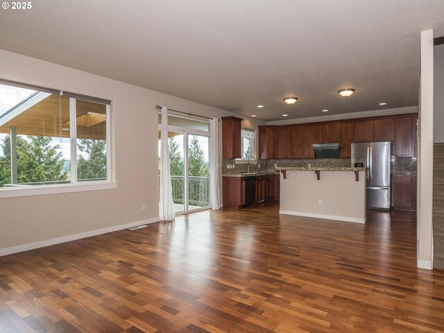 kitchen featuring decorative backsplash, a sink, dark wood-style floors, dishwashing machine, and stainless steel refrigerator with ice dispenser