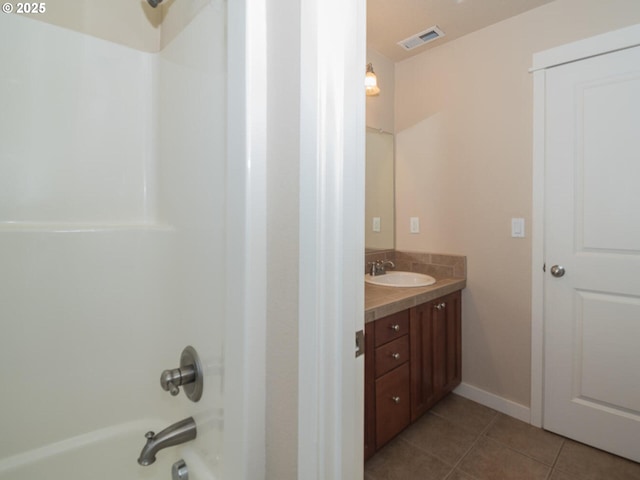 bathroom with tile patterned flooring, shower / bathing tub combination, vanity, baseboards, and visible vents
