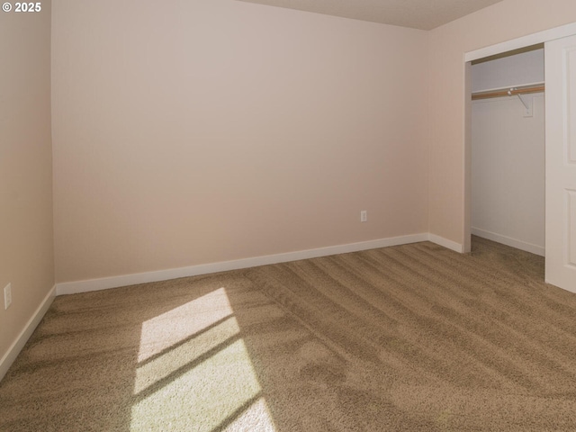 unfurnished bedroom with a closet, carpet flooring, and baseboards