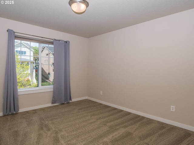 carpeted spare room featuring baseboards