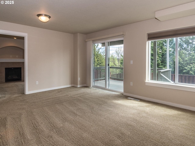 unfurnished living room featuring a fireplace, carpet, and baseboards