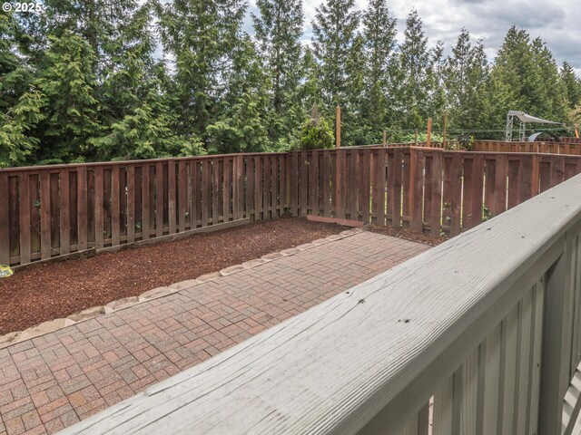 wooden terrace featuring a patio and a fenced backyard