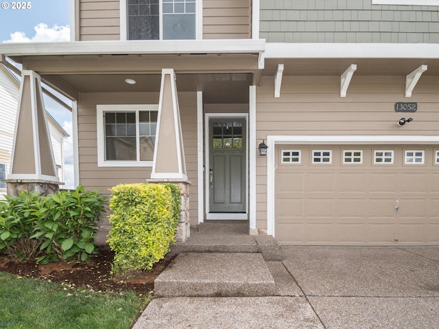 property entrance featuring concrete driveway and an attached garage
