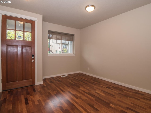 entrance foyer with visible vents, dark wood finished floors, and baseboards