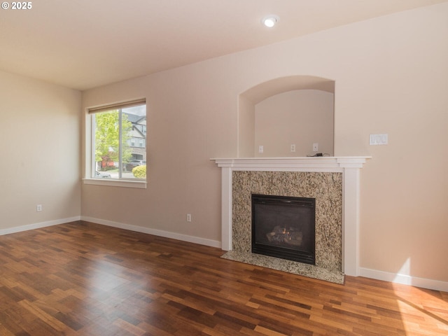 unfurnished living room with baseboards, wood finished floors, and a premium fireplace