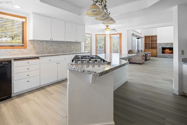 kitchen with light wood-type flooring, pendant lighting, white cabinets, and a kitchen bar