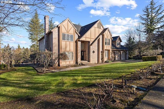 tudor home featuring a garage and a front yard