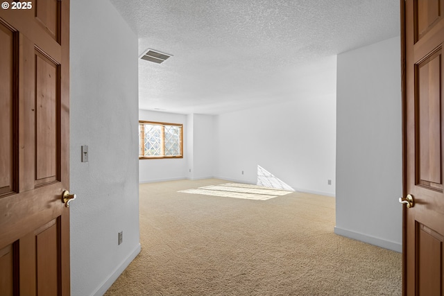 carpeted empty room featuring a textured ceiling