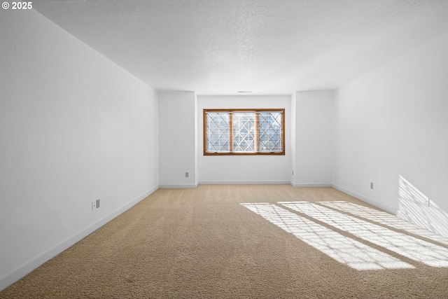 spare room featuring light carpet and a textured ceiling