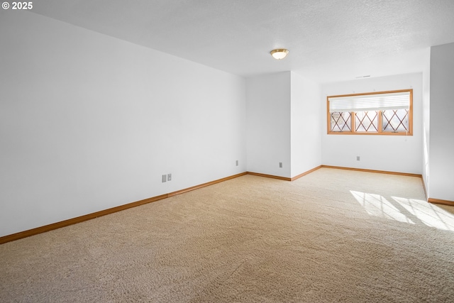 carpeted empty room with a textured ceiling