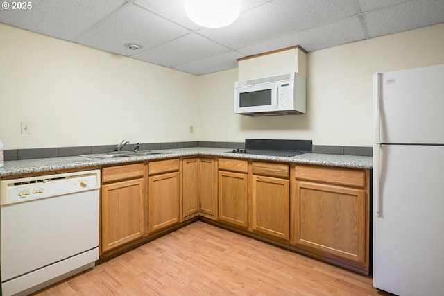 kitchen featuring white appliances, sink, light hardwood / wood-style flooring, and a drop ceiling