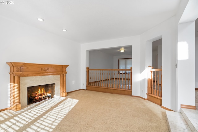 unfurnished living room with light colored carpet and a fireplace