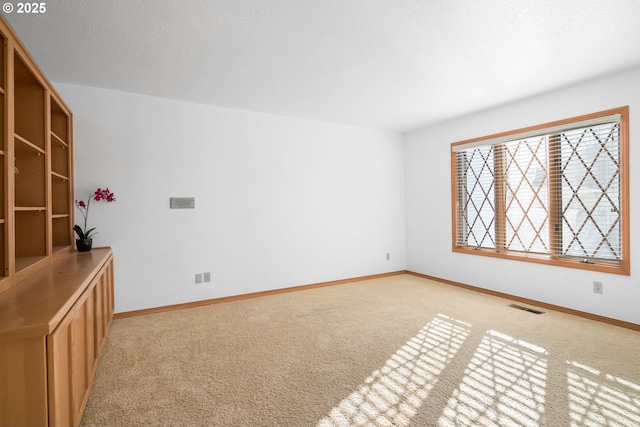 carpeted empty room featuring a textured ceiling