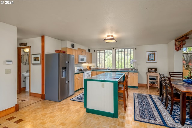 1650 Leatherwood Dr, Eugene, OR 97405 - kitchen with baseboards, a center island, white appliances, and dark countertops