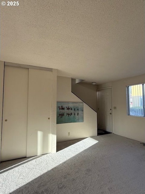 interior space featuring carpet flooring and a textured ceiling