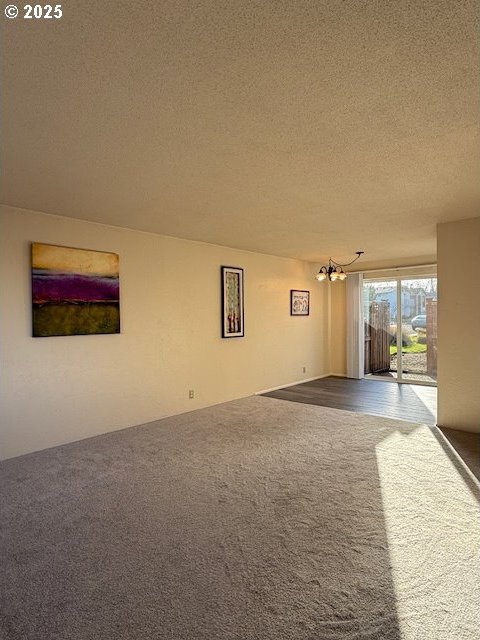 carpeted spare room featuring a textured ceiling