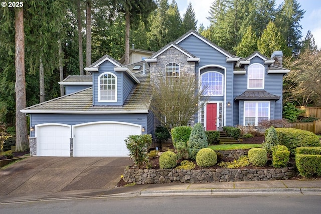 view of front facade with a garage, stone siding, and concrete driveway