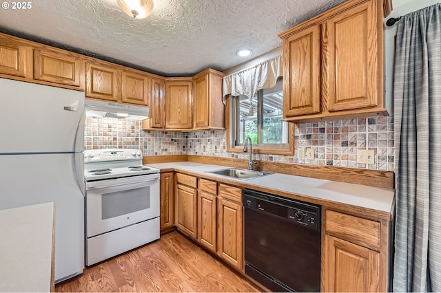 863 NE Fleming Ave Unit B-10, Gresham, OR 97030 - kitchen with white appliances, a sink, under cabinet range hood, light wood-style floors, and light countertops