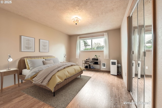 863 NE Fleming Ave Unit B-10, Gresham, OR 97030 - bedroom featuring light wood-style floors, a textured ceiling, and baseboards